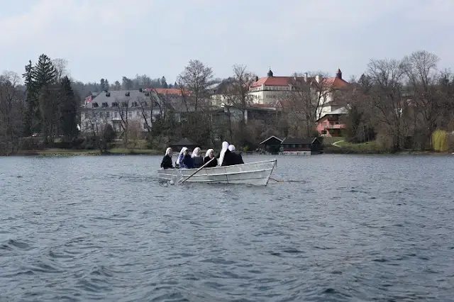 Rowers in long boat on waterfront