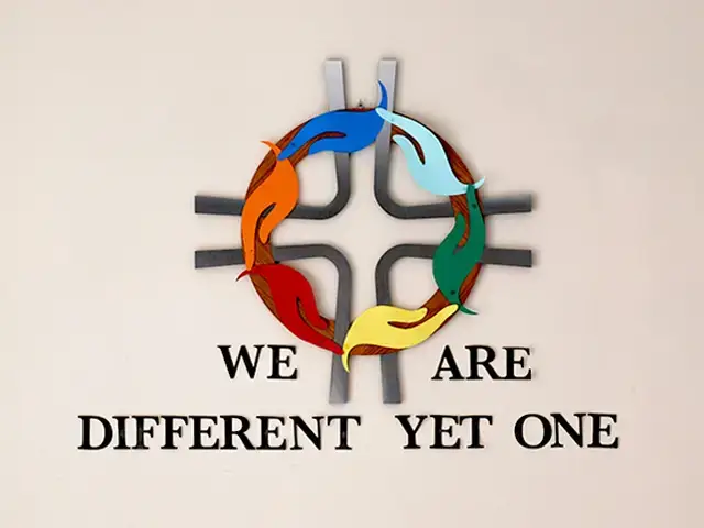 "We Are Different Yet One" logo with colorful hands