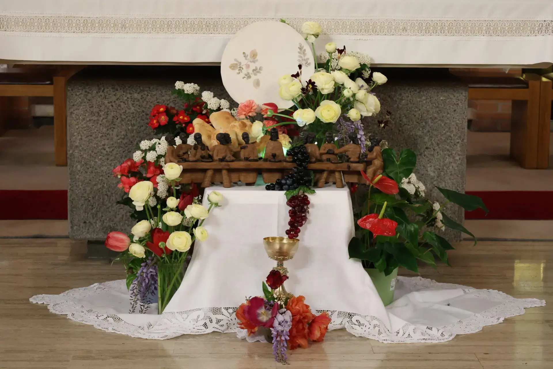 Memorial flower arrangement with roses and framed photo on tiered display